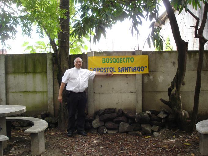 Schild „Bosquecito Apóstol Santiago“ an einer Mauer mit Bäumen